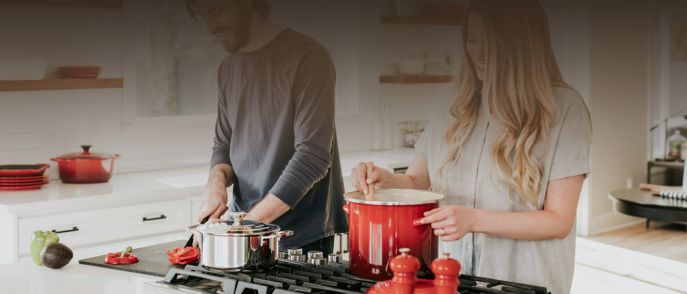 a man and a woman in a kitchen cooking